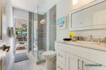 Luxurious hallway full bathroom w/ frameless walk-in shower and outdoor access